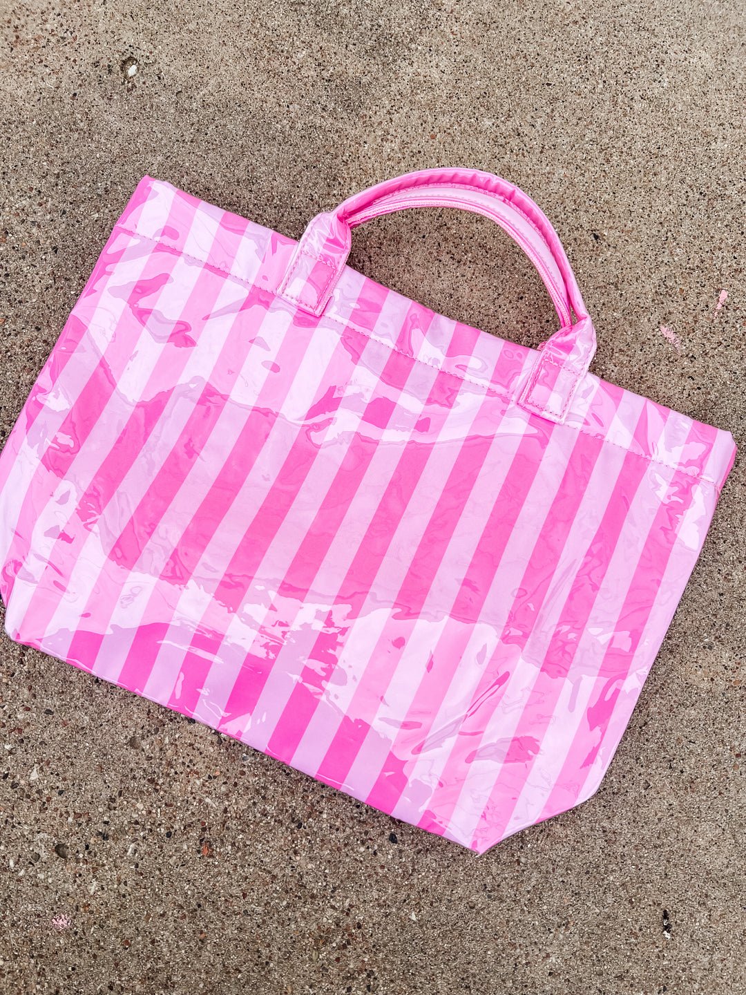 Light and dark pink striped tote bag on concrete ground