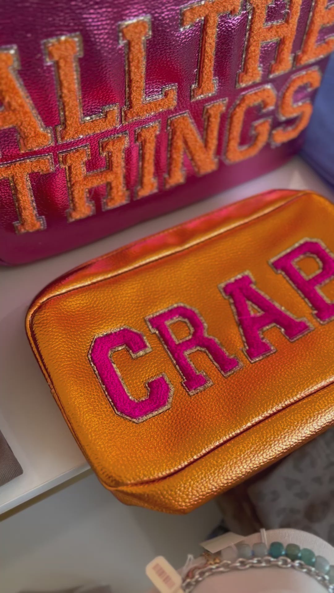 Video featuring cosmetic bags with text"Crap" and "all the things"