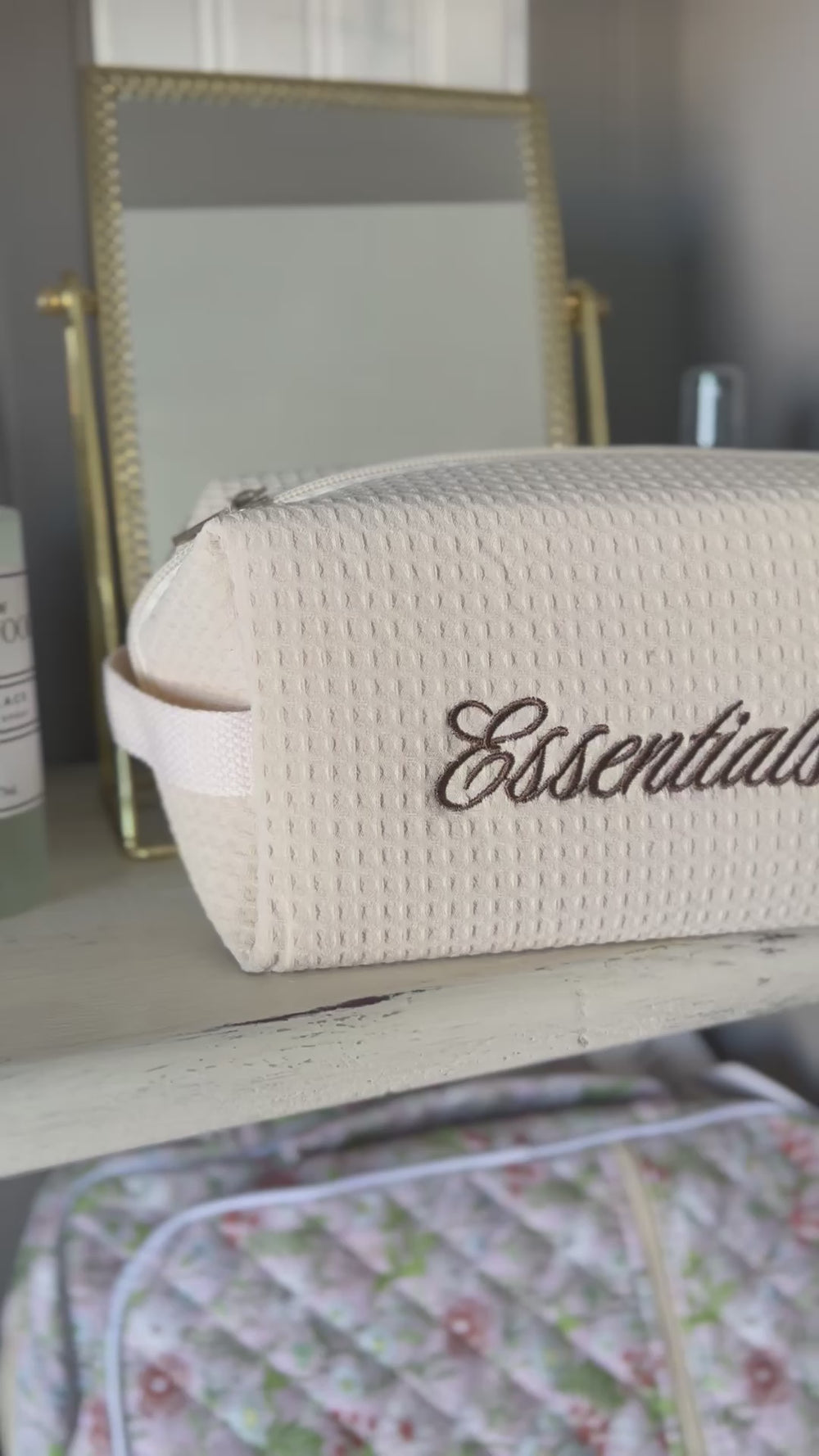 Video featuring cosmetic bag with embroidered text "essentials"