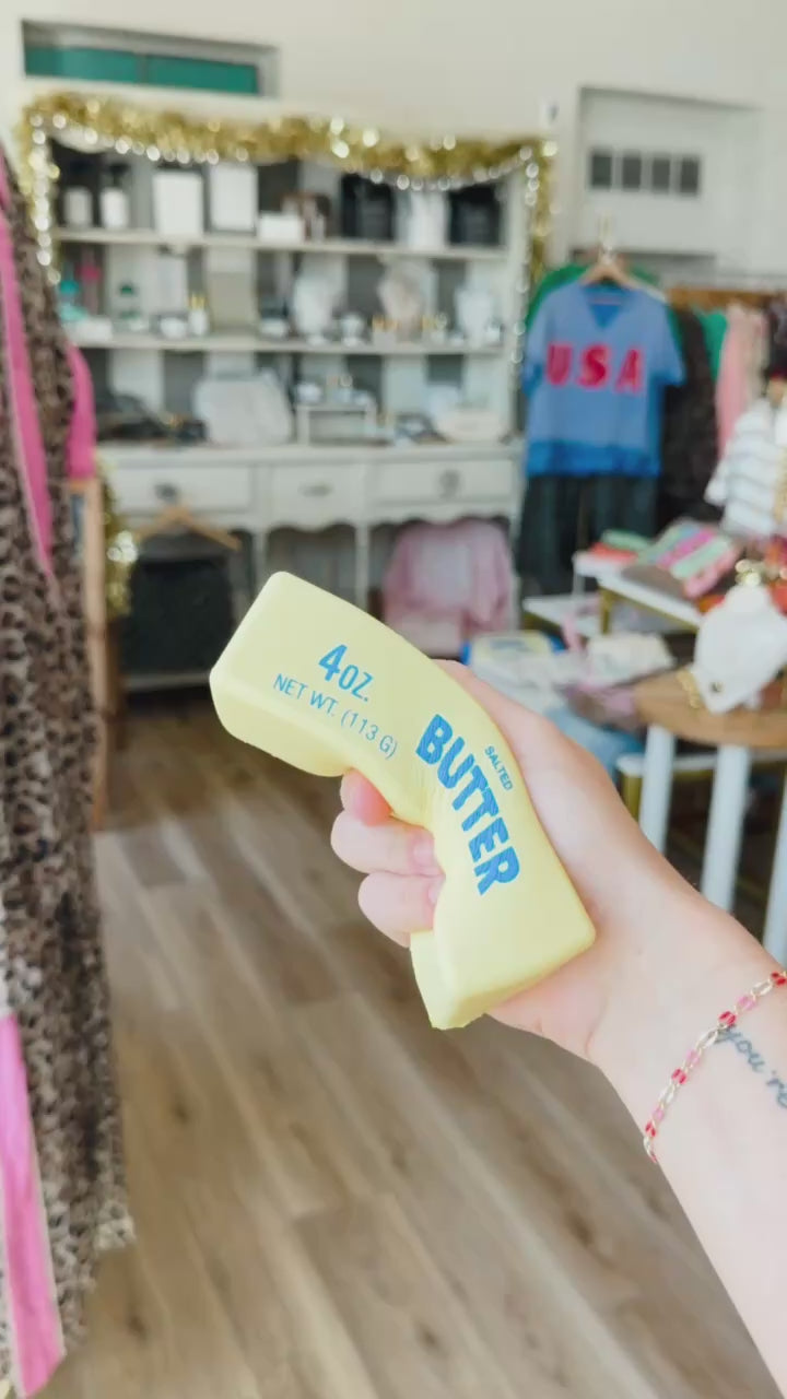 Hand squeezing a squishy shaped like a butter stick