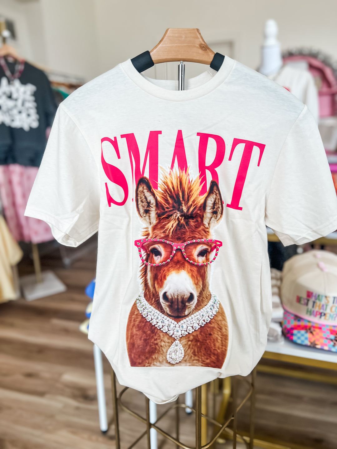 White t-shirt with a donkey graphic and 'SMART' text on a hanger.