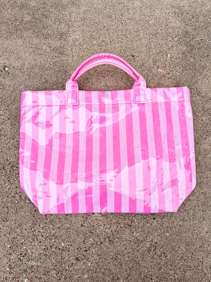 Pink and white striped bag on a concrete surface